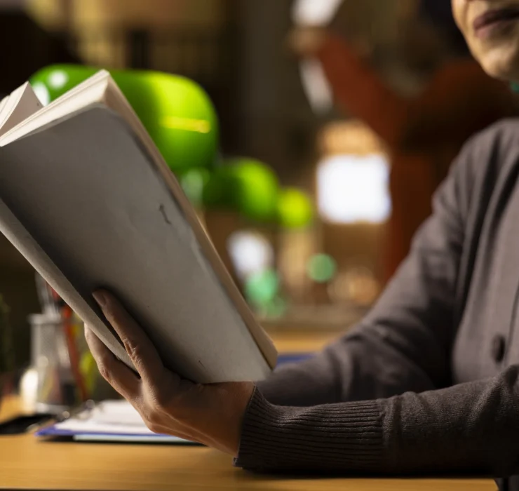 focused-adult-woman-with-book-hand-studying-quiet-library-space (1)